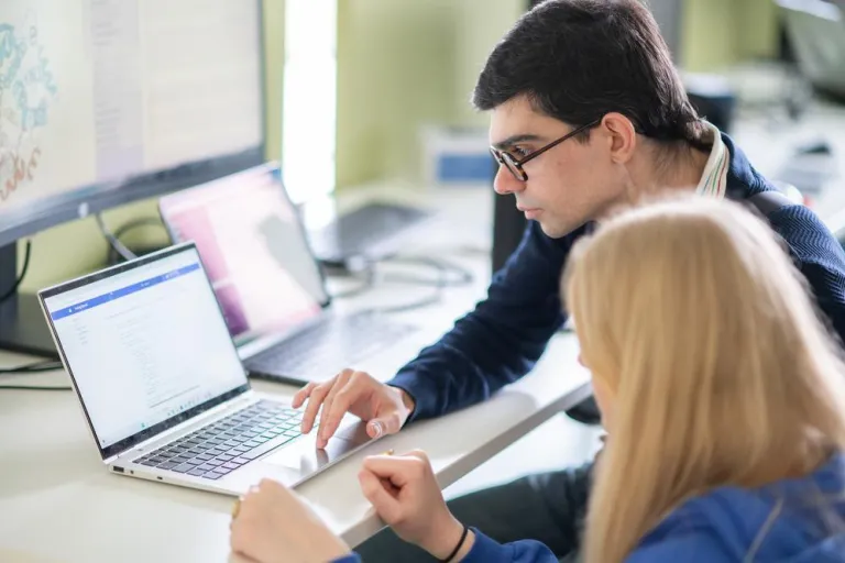 man and woman looking at computer screen
